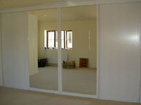 White sliding doors with mirror doors, with design on.